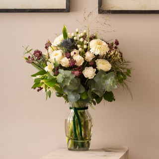 Bouquet of flowers in a clear vase on a neutral background